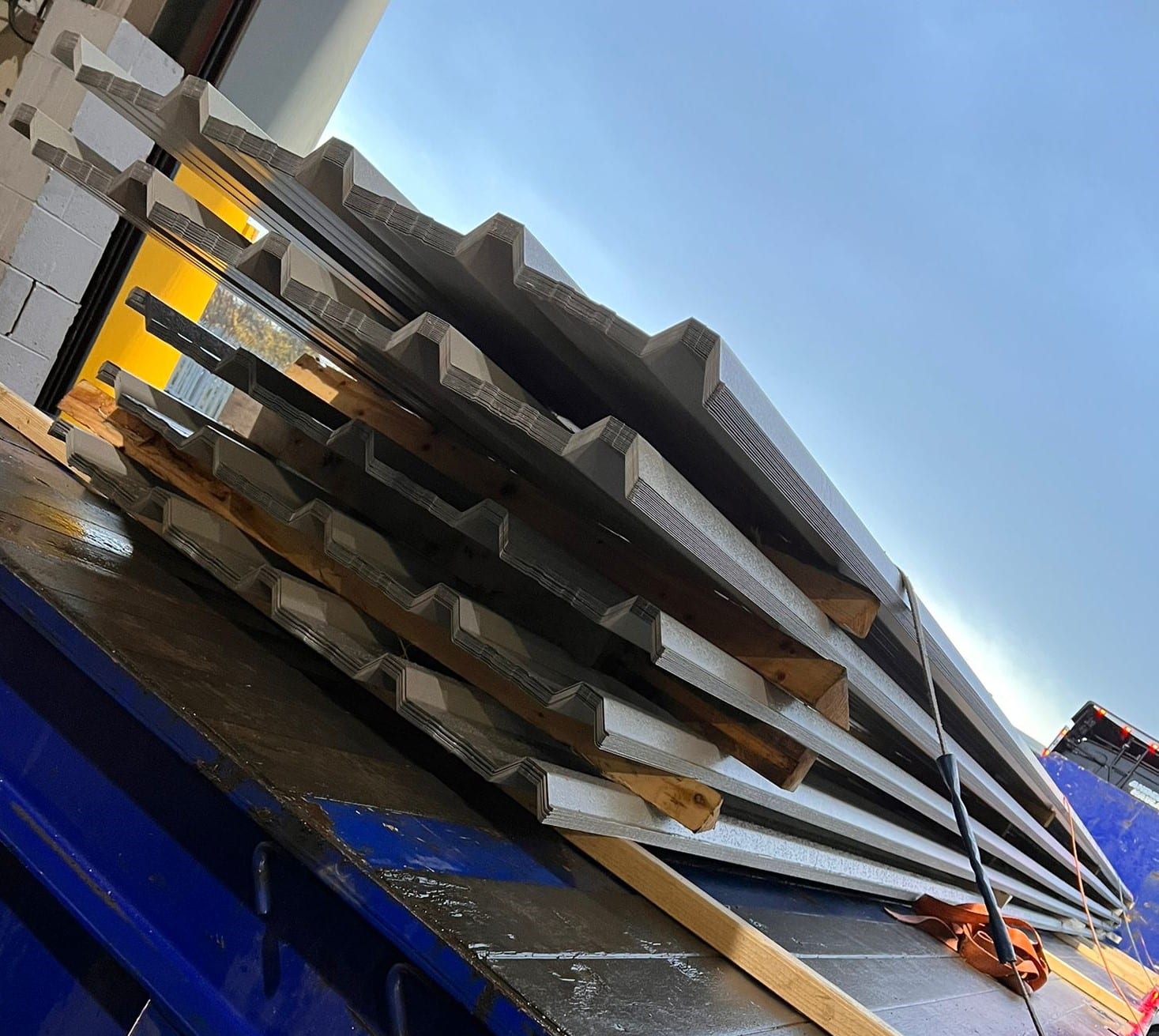 five piles of box profile roof sheets stacked onto a lorry