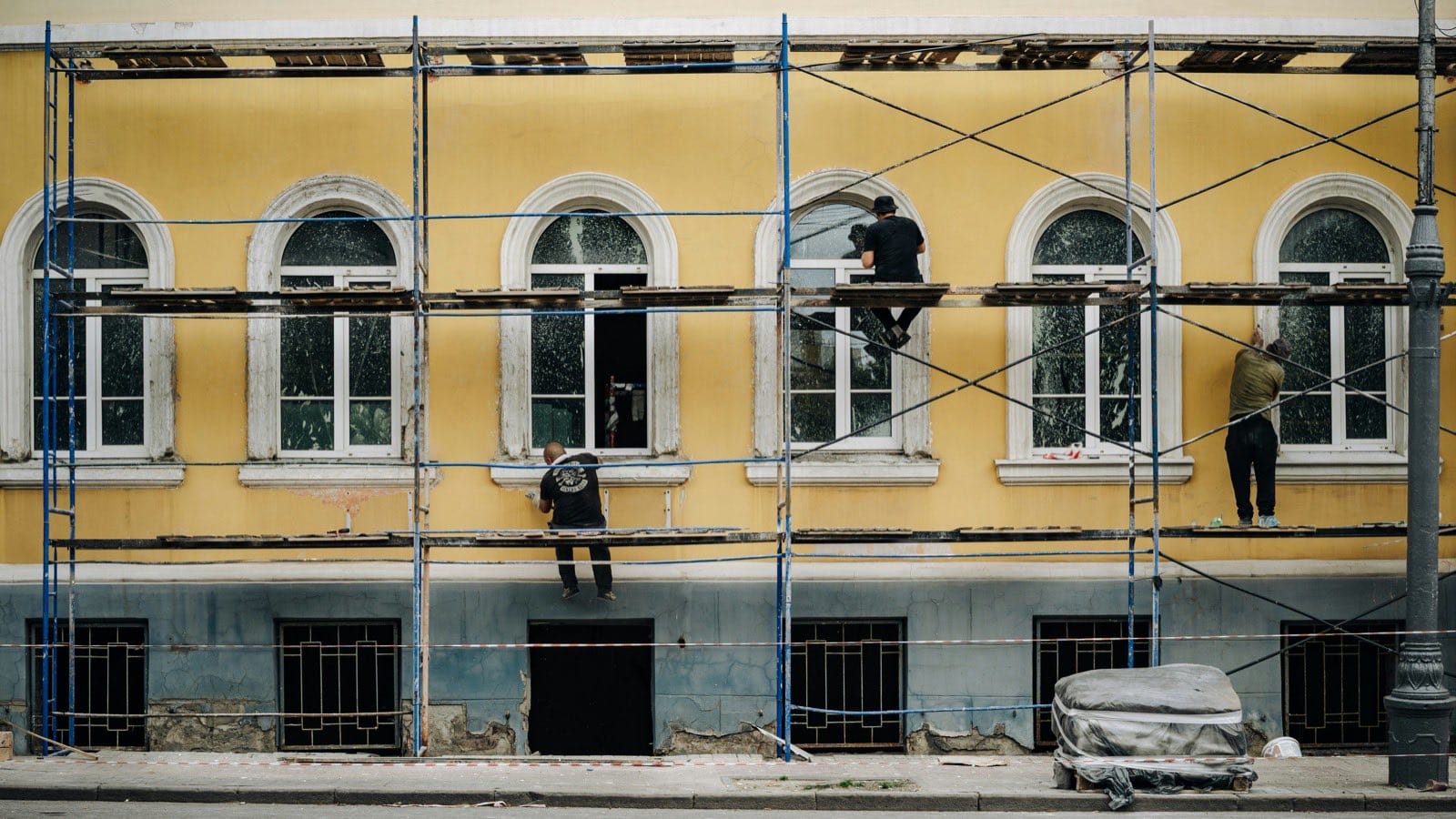 Workers on scaffolding repairing a building facade