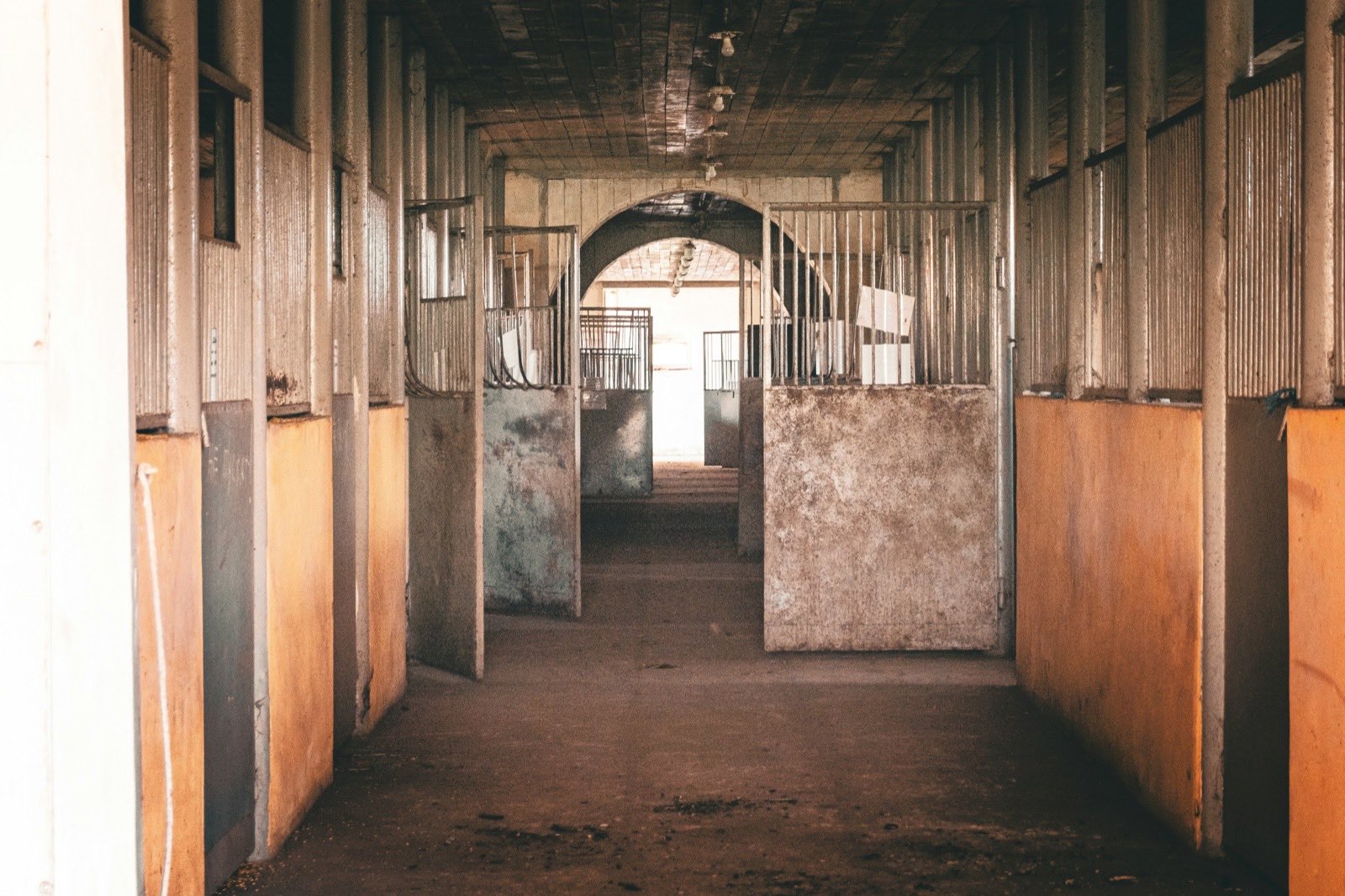 rustic horse stable corridor with open stalls