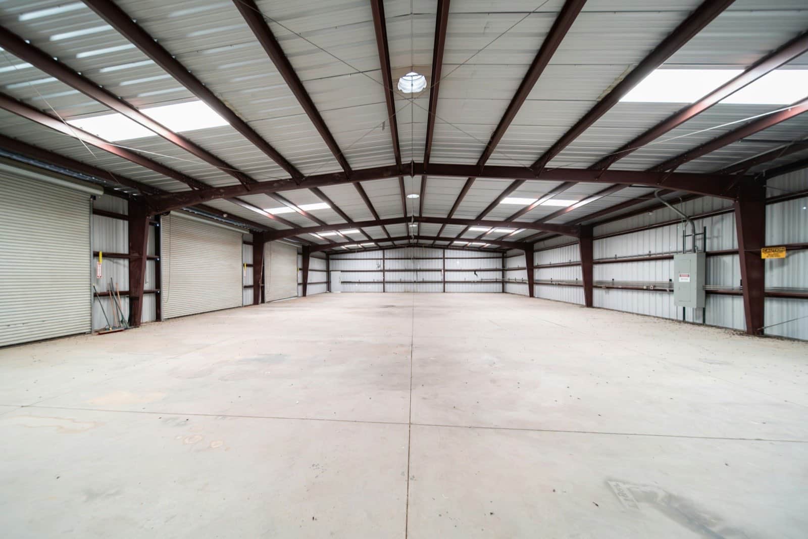 interior of a large empty warehouse with a steel roof