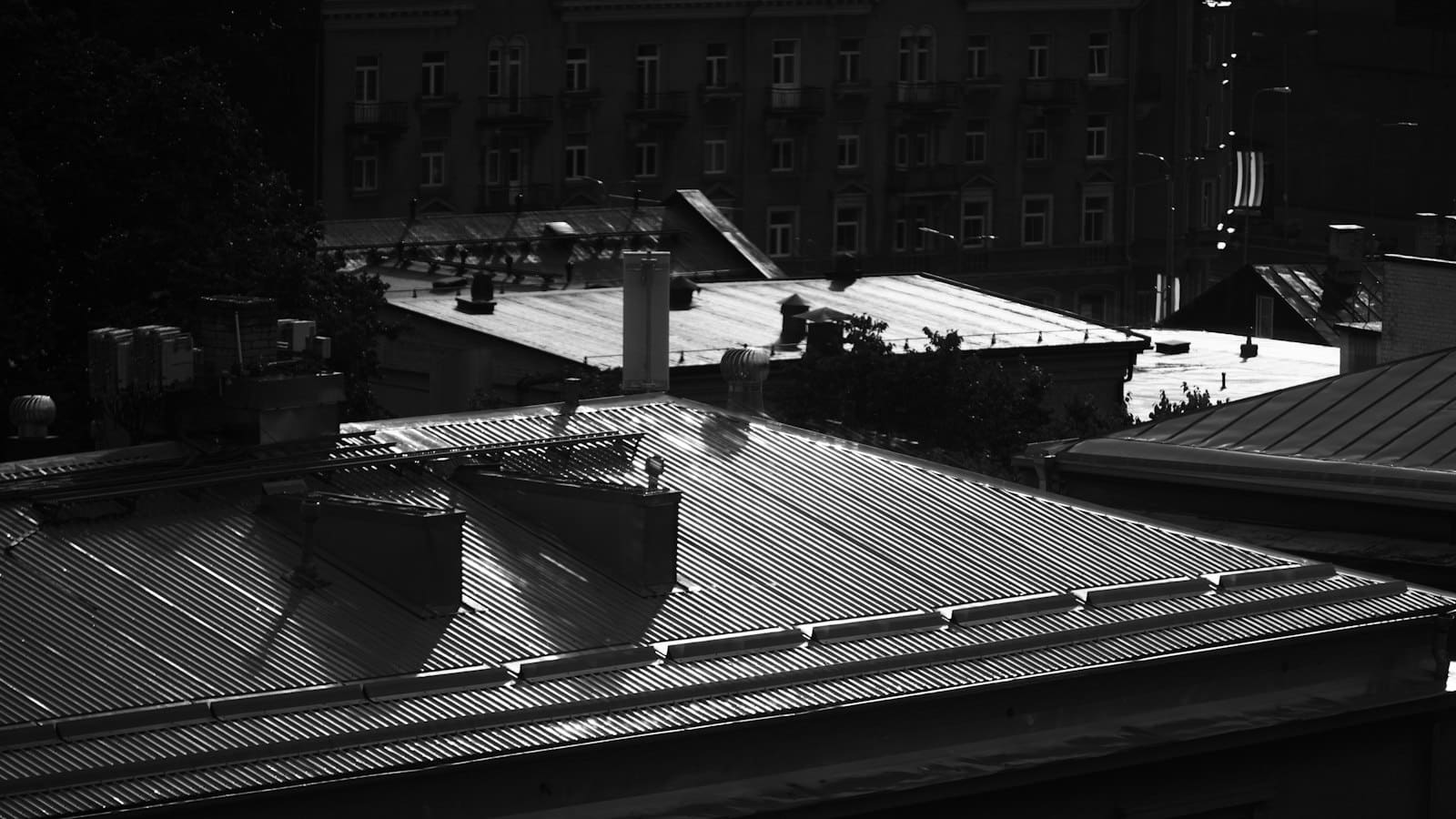 Corrugated metal roofs on urban buildings in high contrast black and w