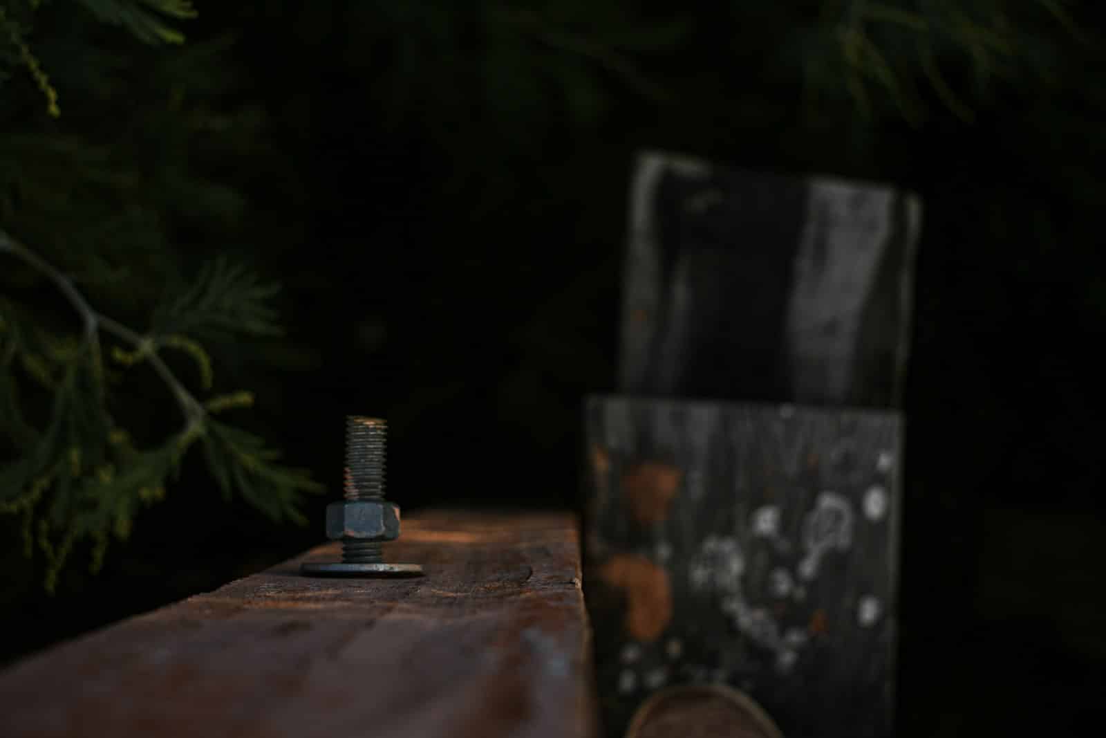 Bolt and nut on a wooden surface with blurred background